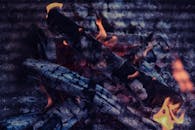 篝火图像中，烧焦的原木燃烧着可见的火焰