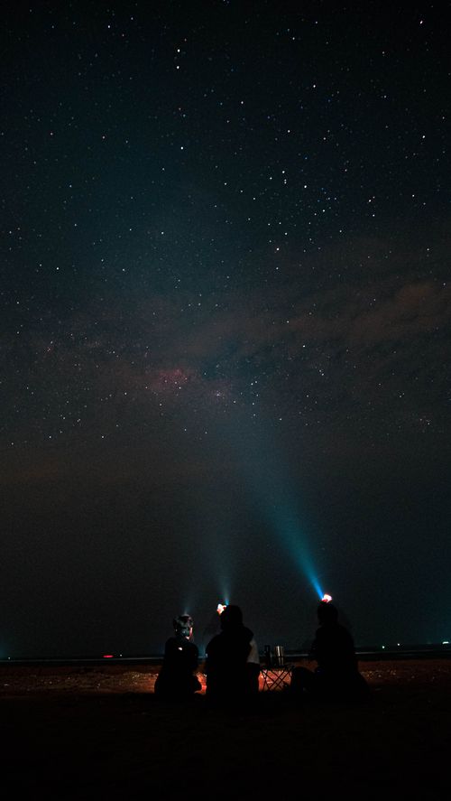 Free Silhouettes observing the starry night sky with flashlights, creating a captivating scene in Vietnam. Stock Photo