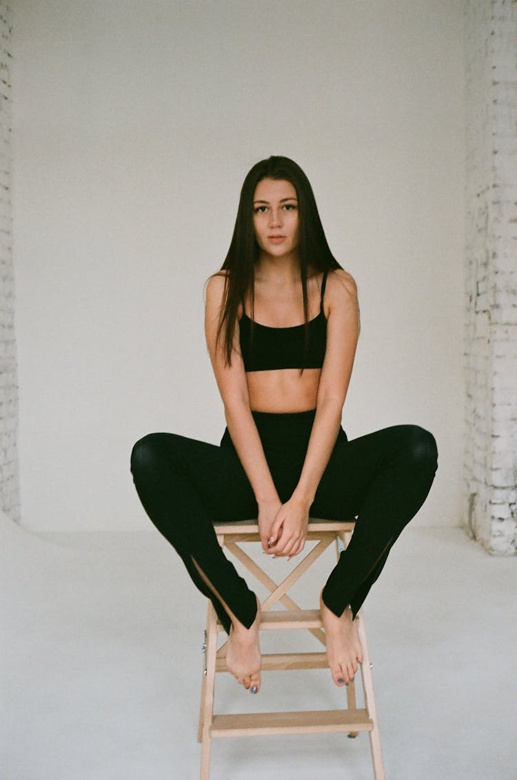 Woman Sitting On Stool Posing In Studio