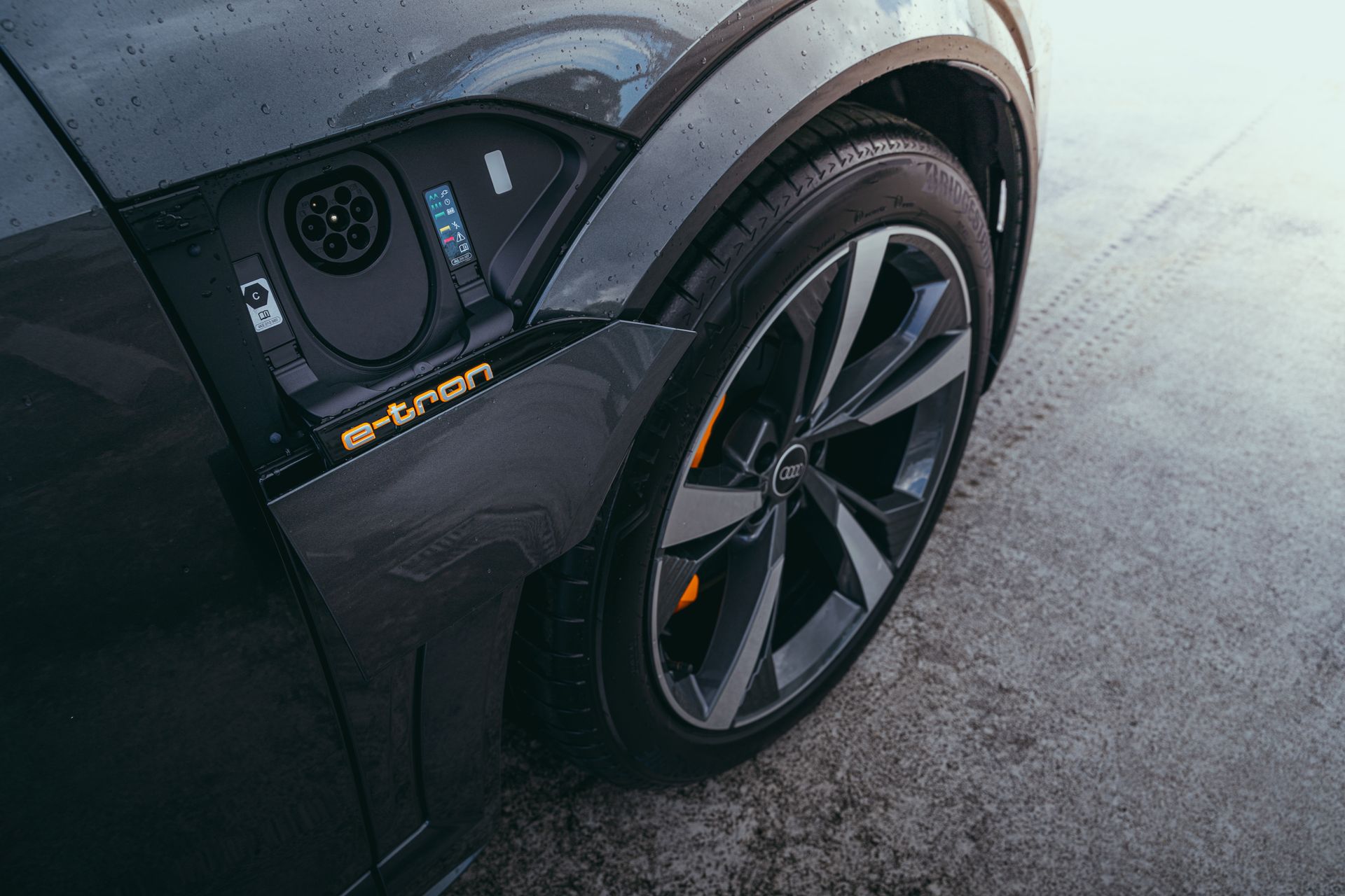 Detailed view of an electric car's charging port and wheel, captured in Curitiba, Brazil.