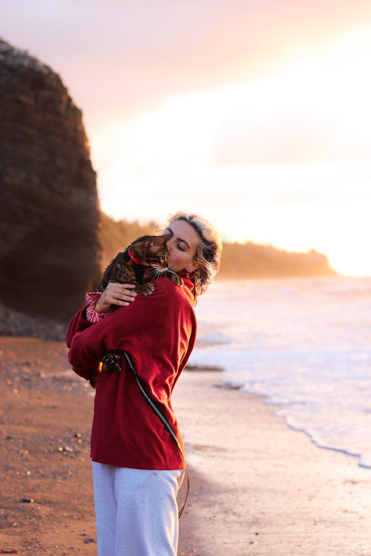 Woman Hugging Her Cat On The Beach 