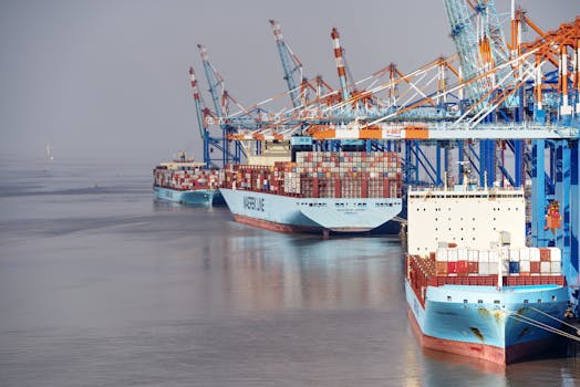 Container ships docked at a busy port with vibrant cranes and clear skies.