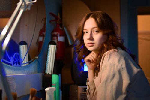 Free Portrait of a young woman indoors, reflecting in a mirror with a thoughtful pose. Stock Photo