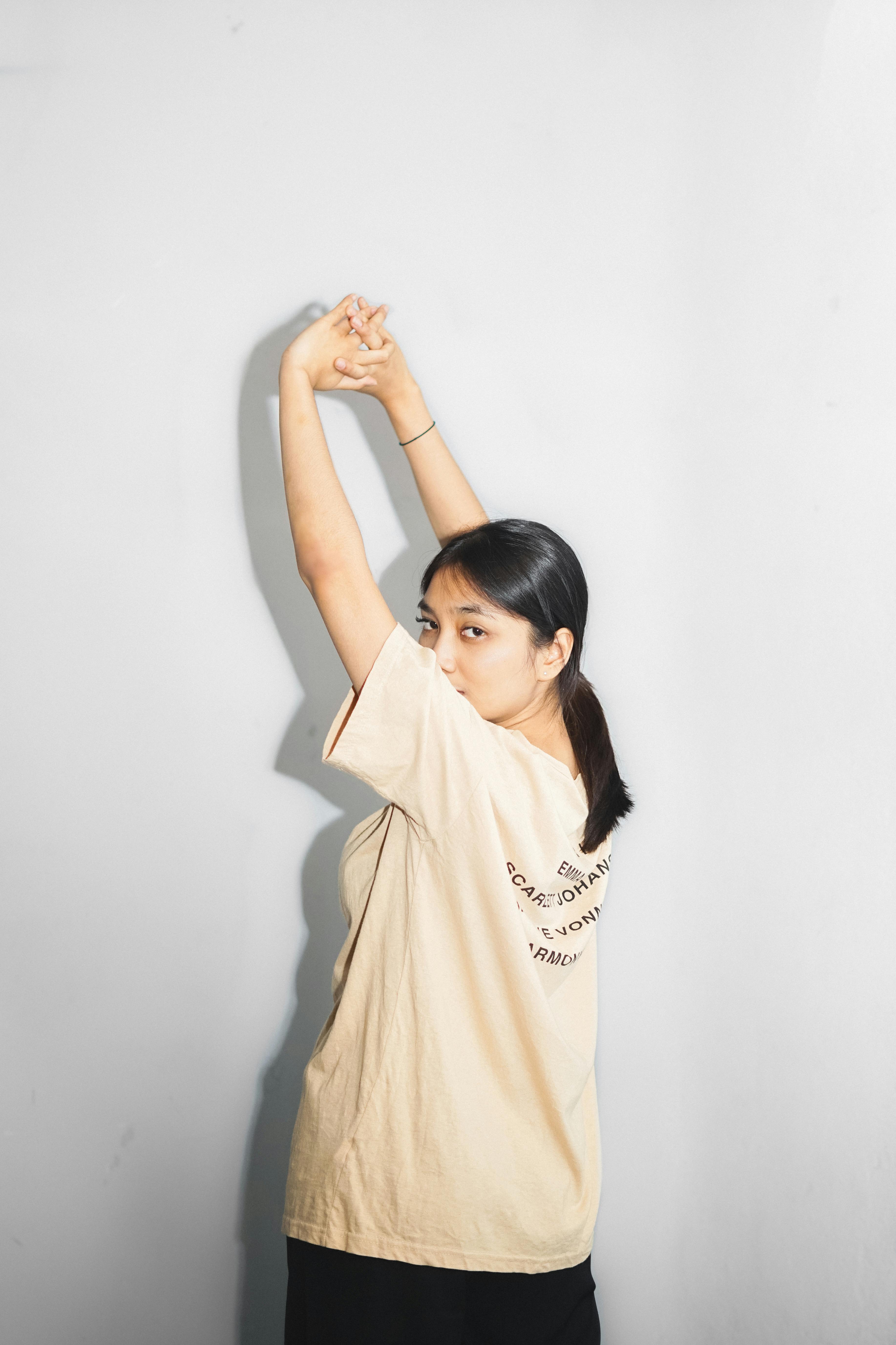 Woman in Beige Shirt Raising her Hands · Free Stock Photo