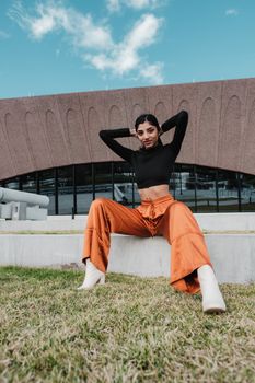 Fashionable woman in vibrant pants poses outside a modern building in Winter Park, FL.