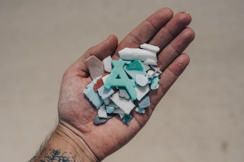 Free Close-up of a hand holding colorful plastic fragments, highlighting environmental concerns. Stock Photo