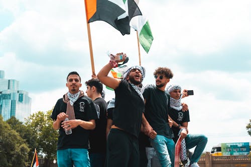 Free A Group of Men with Black and White Turbans Holding Flags During a Protest Stock Photo