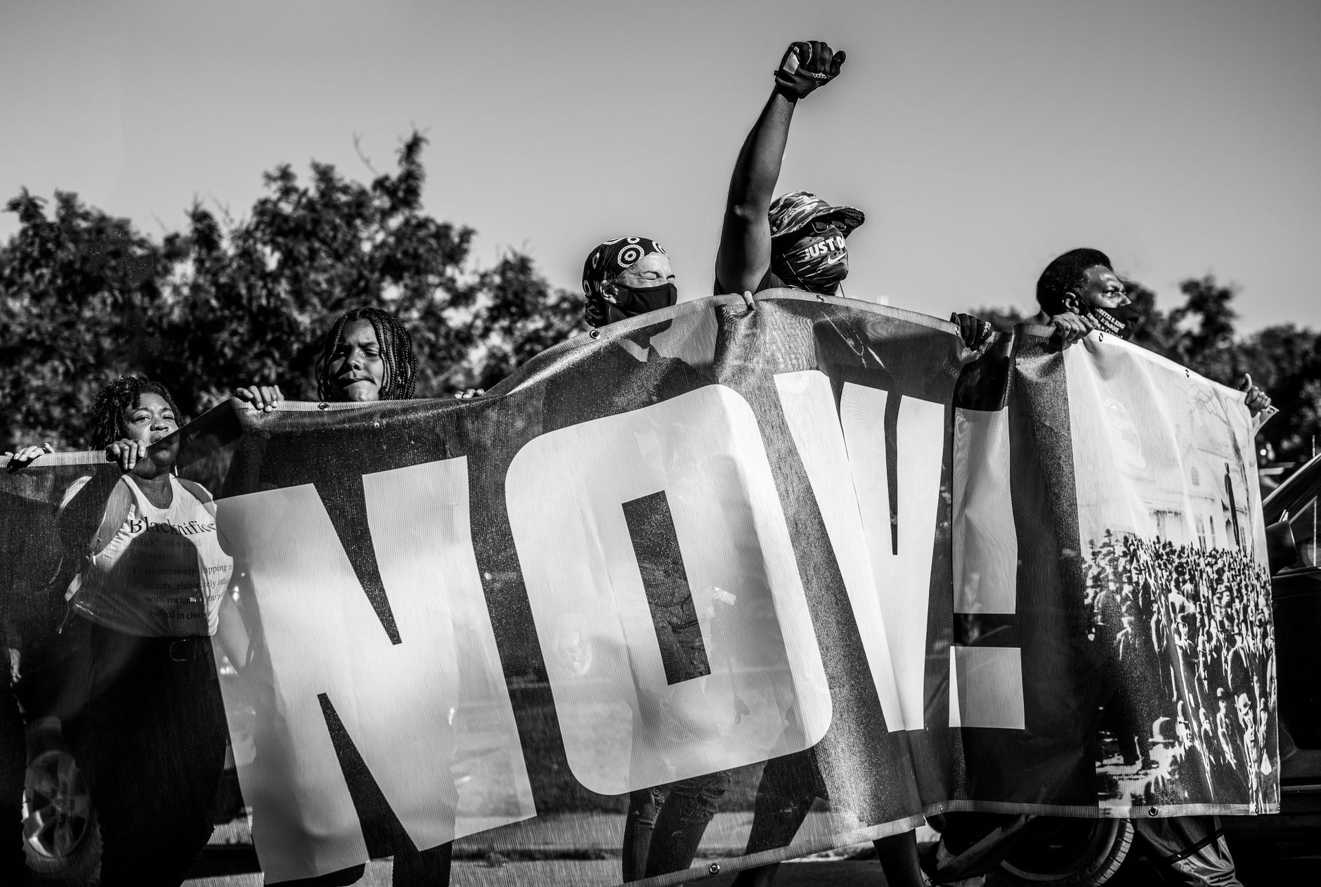 Protesters unite with a powerful banner at an outdoor demonstration, demanding justice.