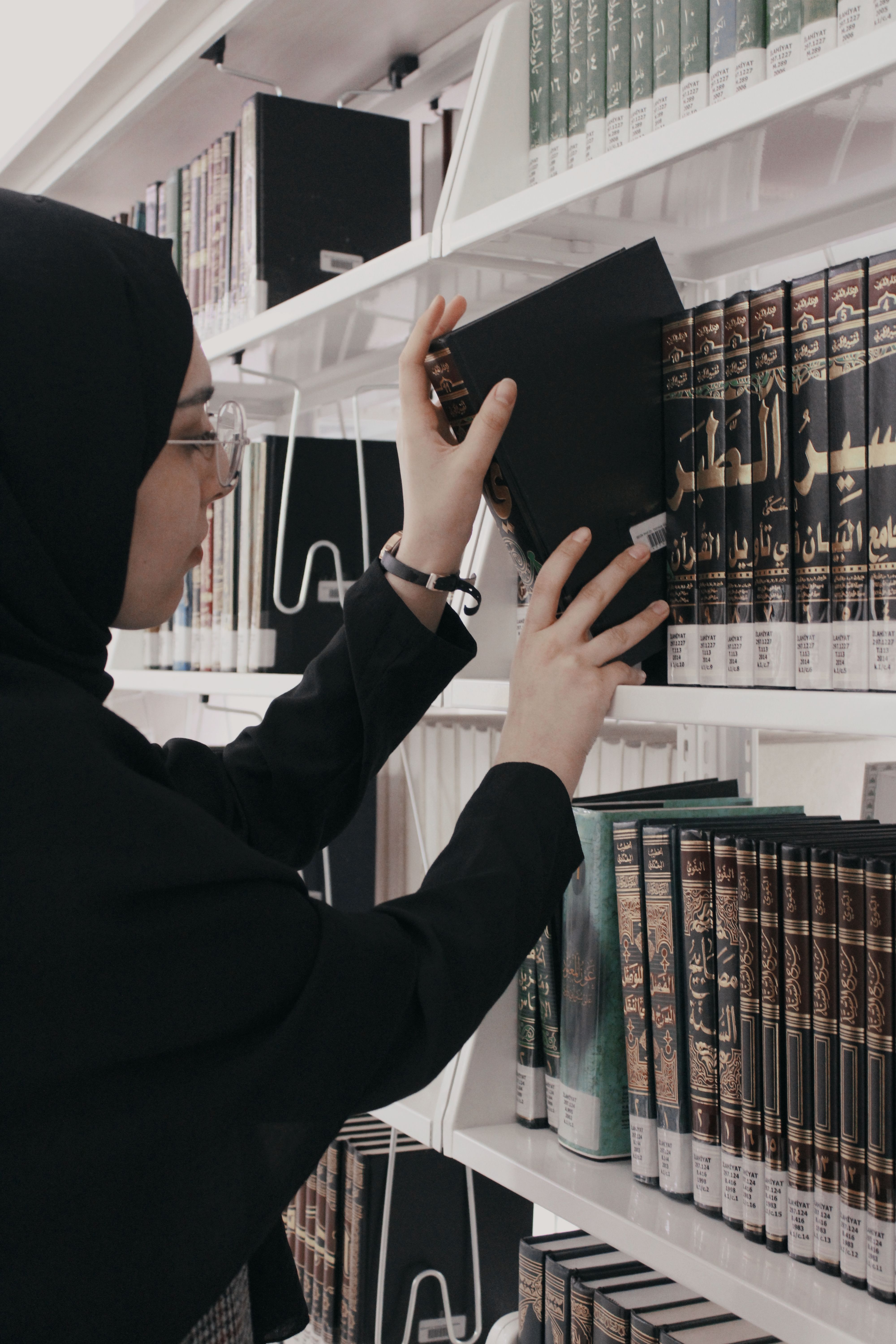A Woman in Black Hijab Holding a Book · Free Stock Photo