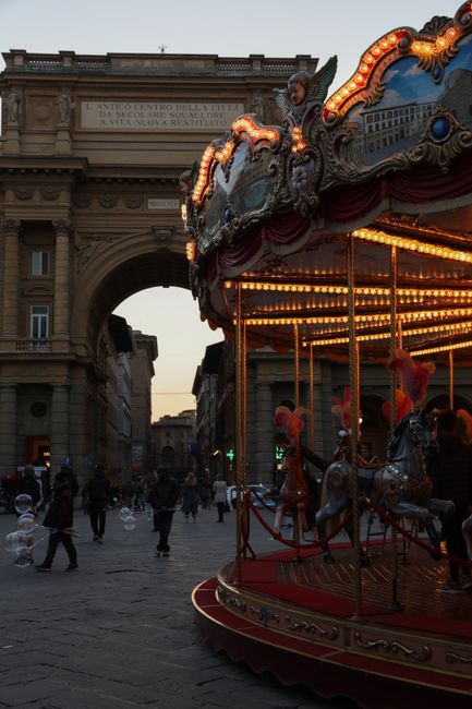A lively carousel beautifully illuminates the historic square at twilight.