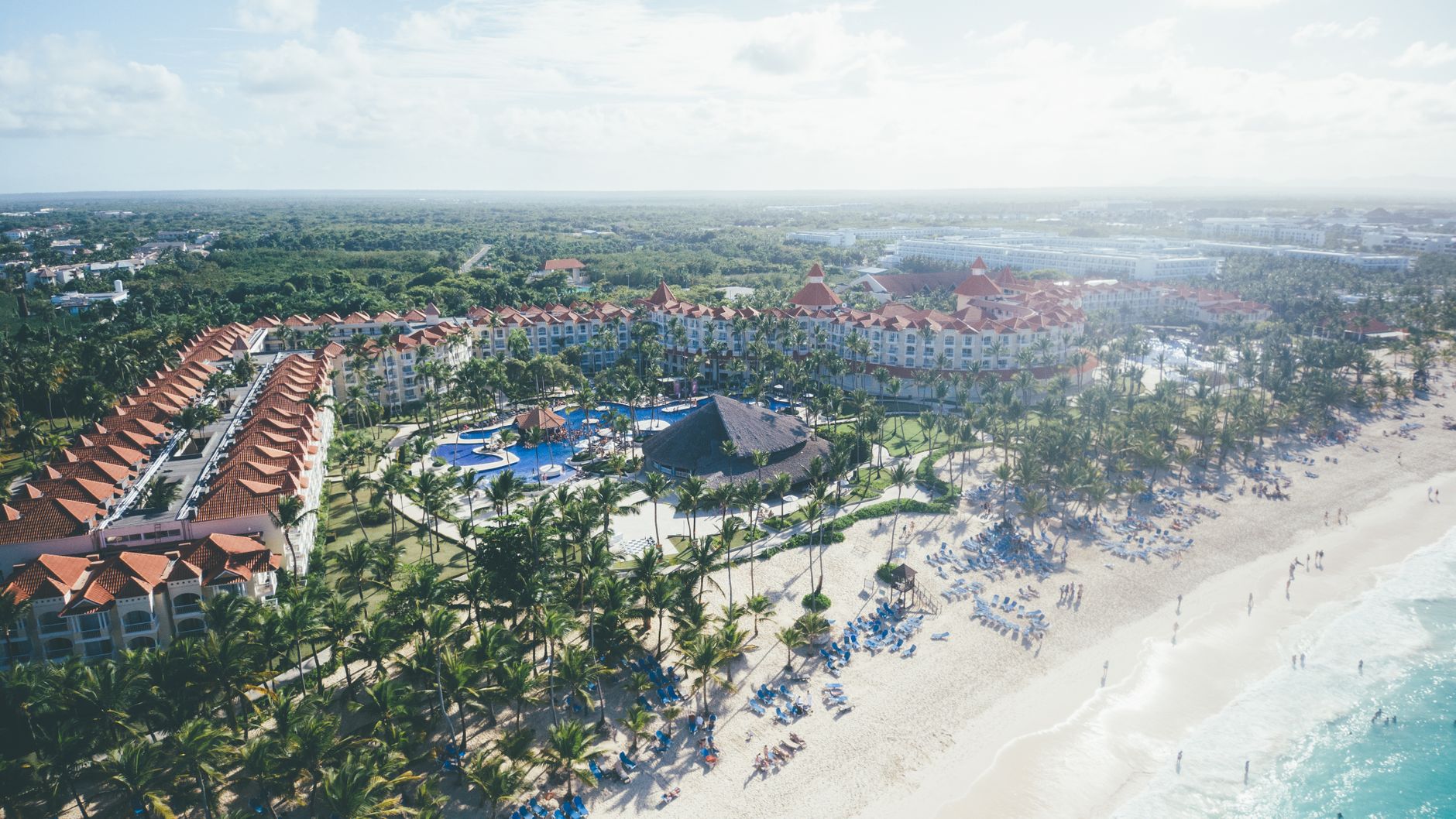 Aerial shot of a tropical beach resort in Punta Cana with palm trees and ocean views.