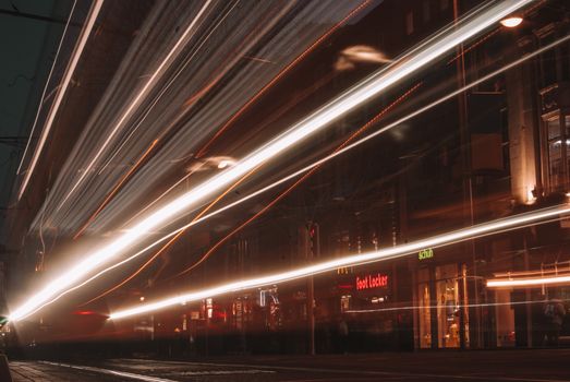 Long exposure capture of light streaks on a bustling city street at night, showcasing urban energy.