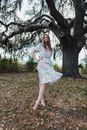 Woman in White Floral Dress Standing Under Tree