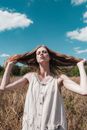 Woman in White Sleeveless Dress Standing on Brown Grass Field