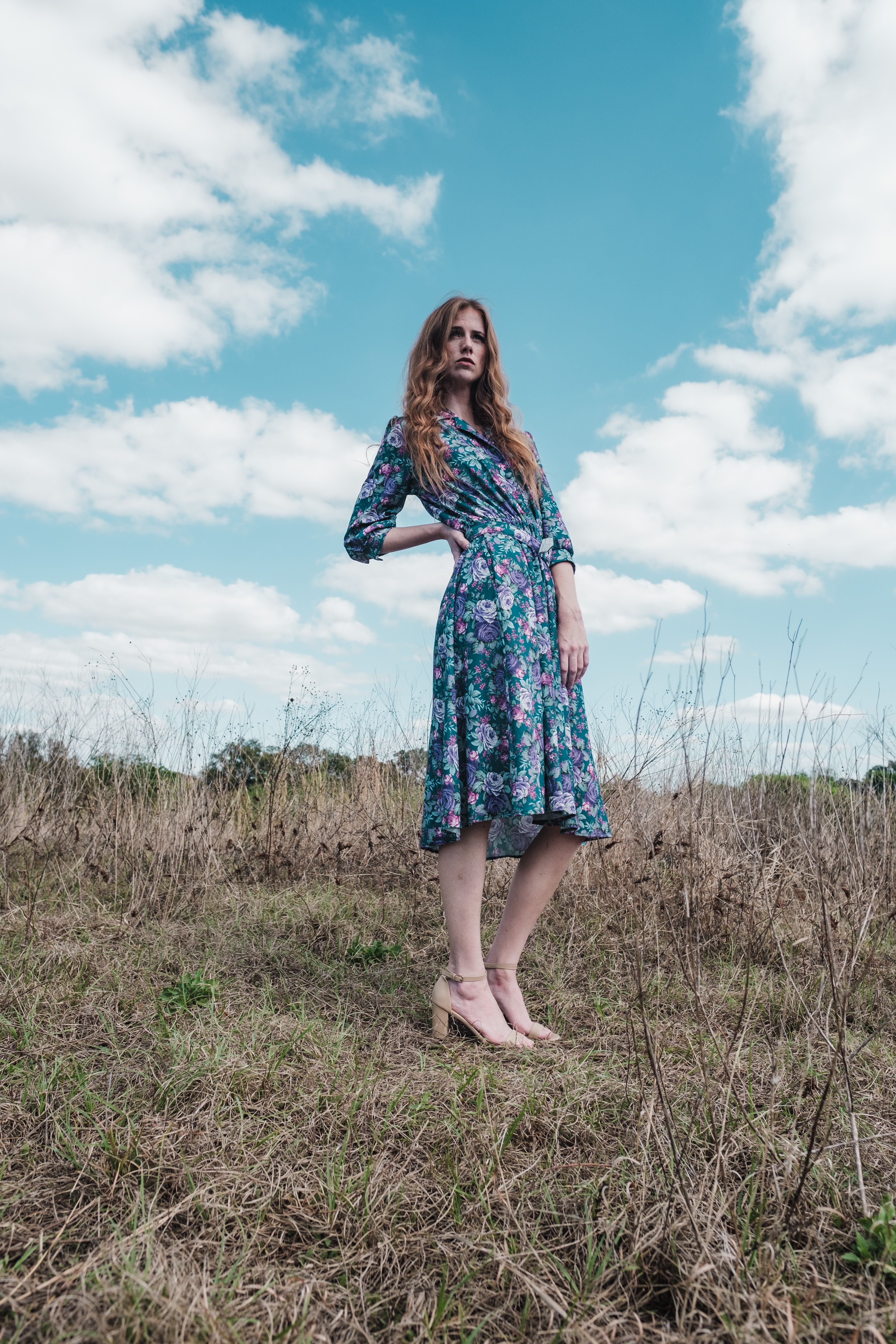 Woman in Floral Dress Posing Near the Glass Wall · Free Stock Photo