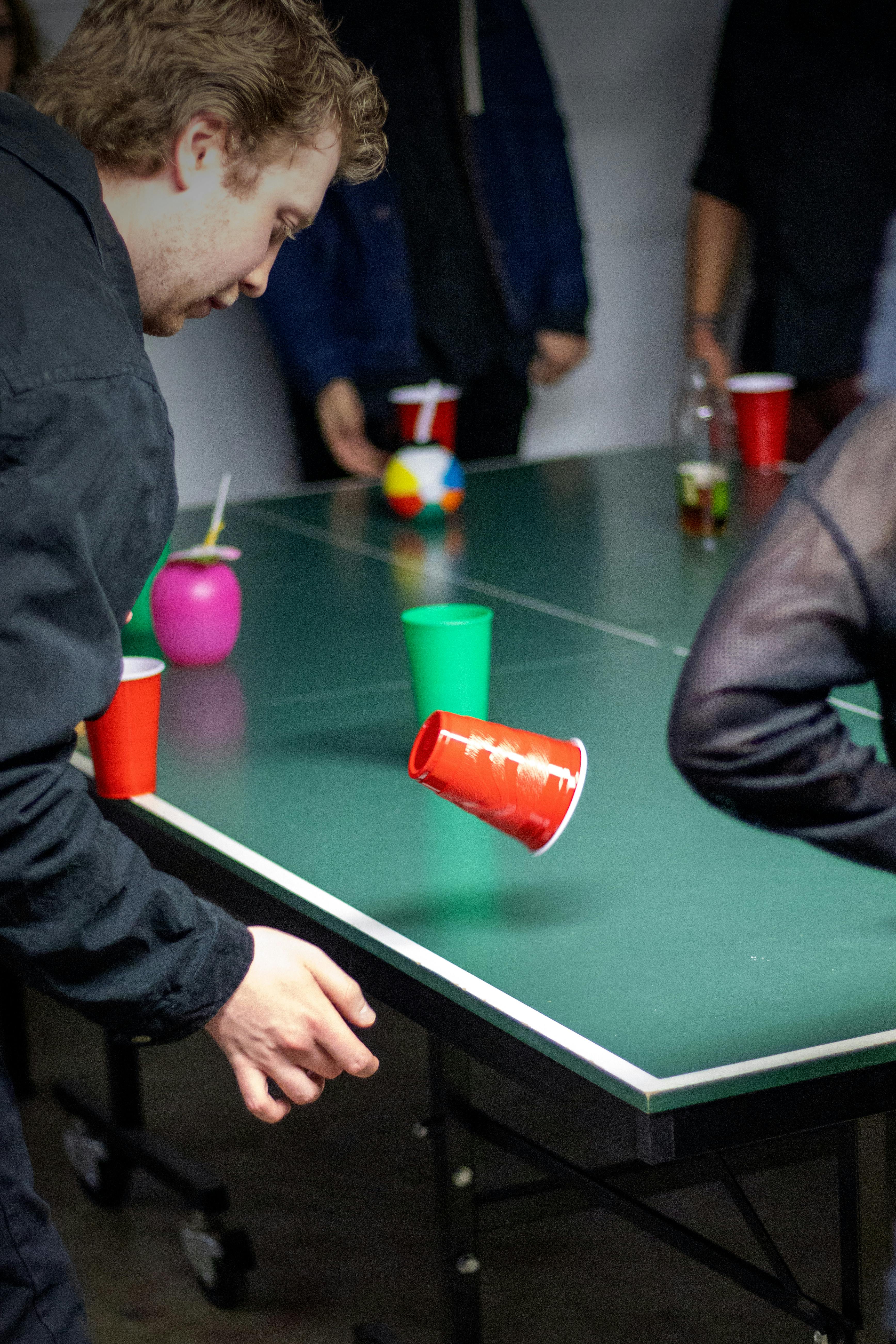 man playing games using a red cup