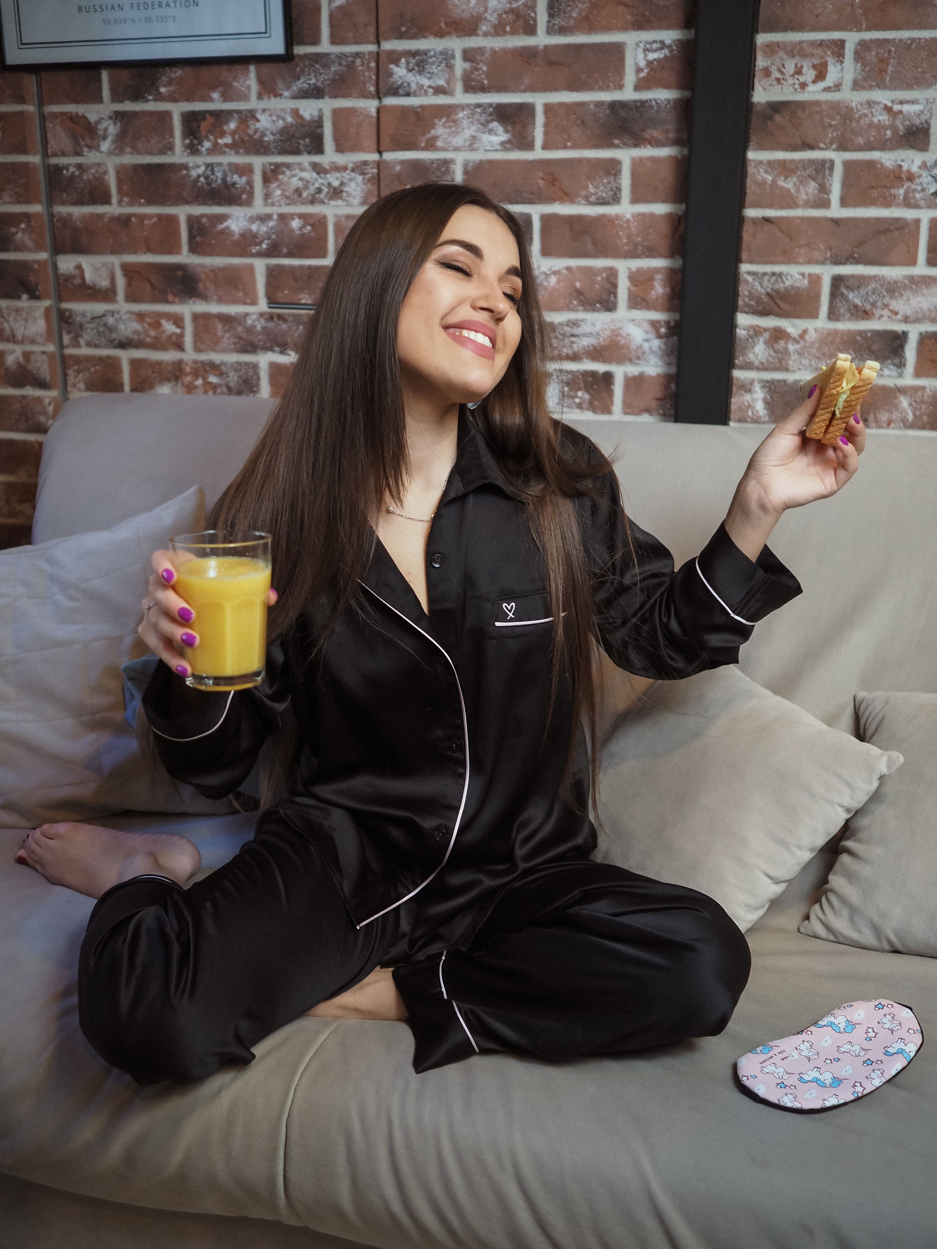 Jovem mulher de pijama curtindo uma manhã feliz com café da manhã em casa.