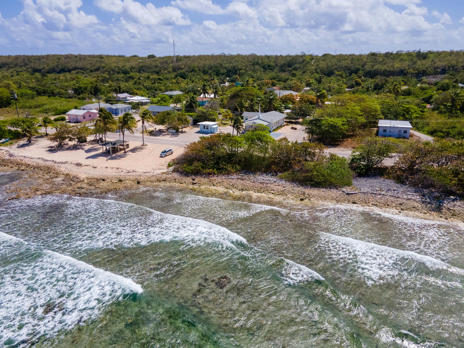 A serene aerial view of the beach and lush greenery at Sister Islands, Cayman Islands.