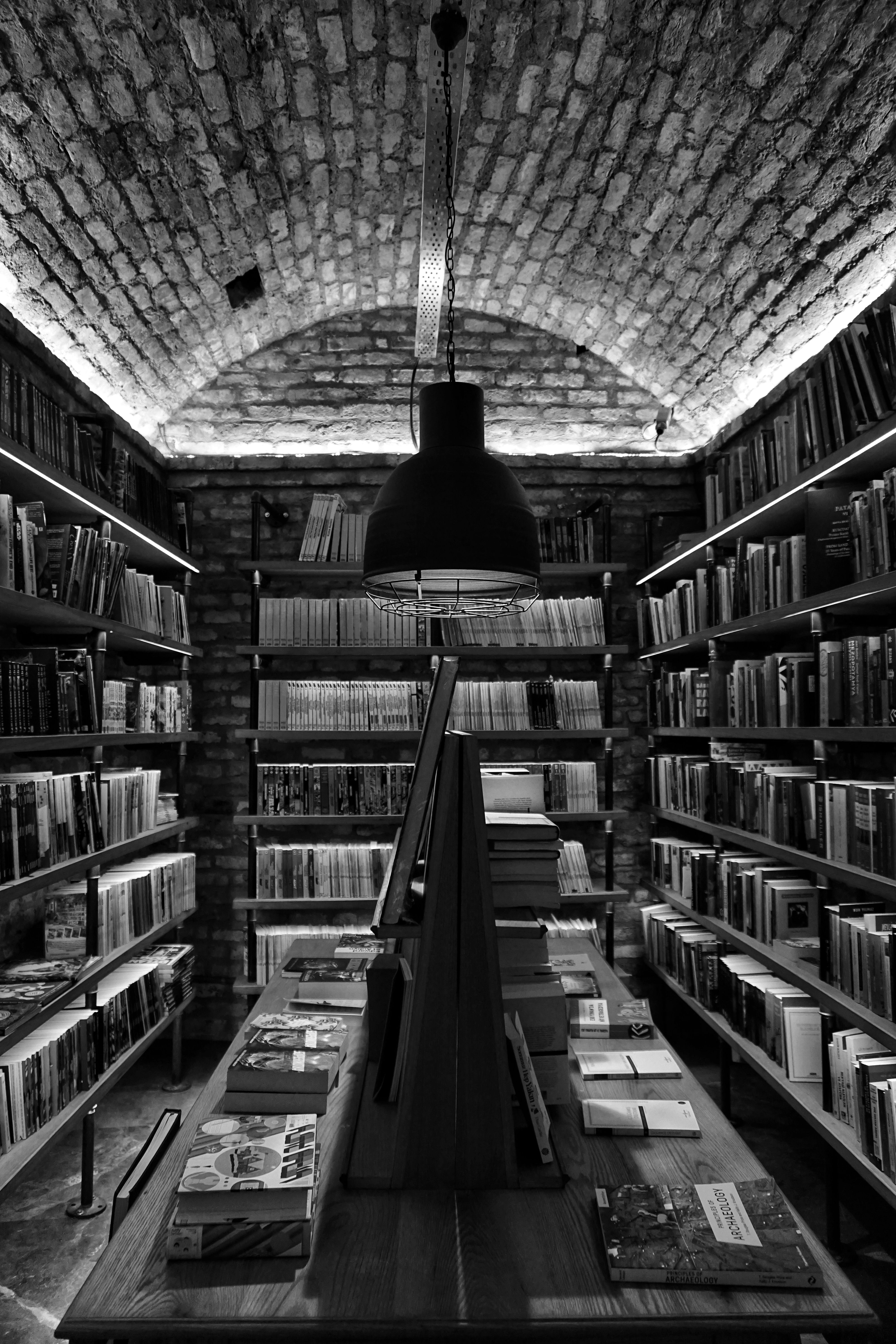 Grayscale Photo of Books on Shelves · Free Stock Photo