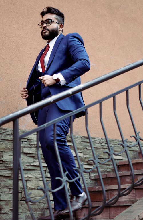 Free Professional man in a blue suit walking down stairs outdoors. Stock Photo