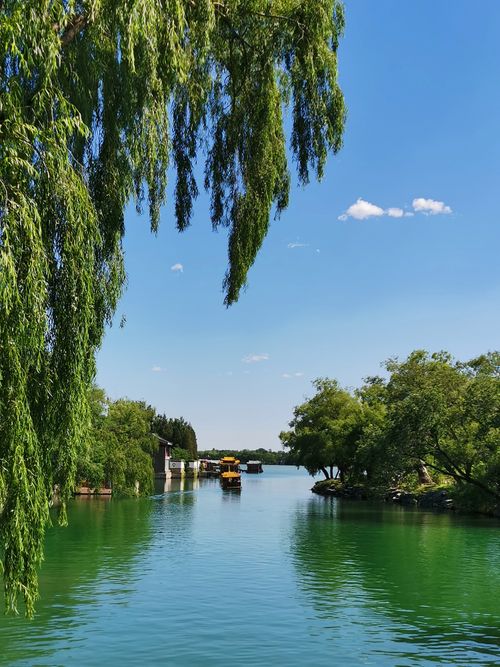 Free Tranquil summer scene of a canal with lush trees and boats in Beijing, China. Stock Photo