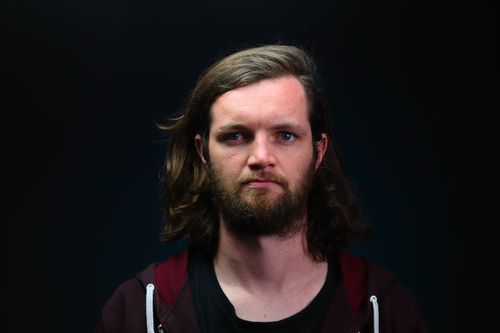 Free Striking portrait of a man with long hair and beard in a dark setting. Stock Photo