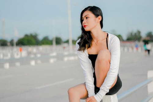 A Woman with Red Lips Sitting while Looking Away