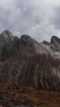 Stunning view of rocky mountains with dramatic cloud cover, showcasing natural beauty and earth's textures.