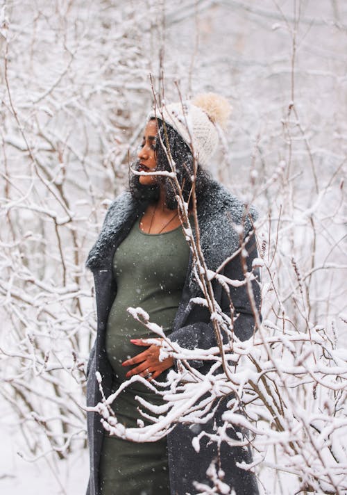 A Woman in Gray Coat Standing on the Snow