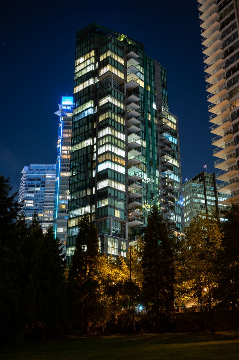 Illuminated Bellevue high-rise tower at night above the treeline