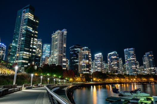 Stunning night view of Vancouver's modern skyline by the waterfront, reflecting city lights.