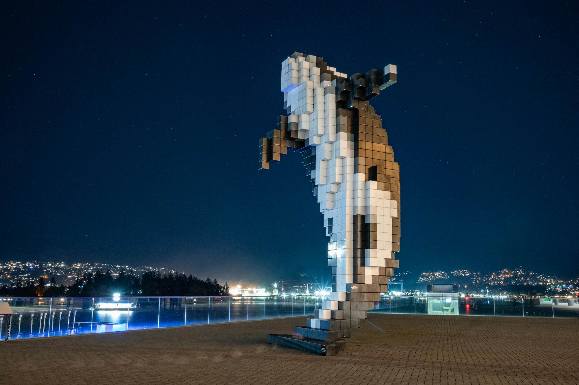 Stunning night view of the Digital Orca sculpture in Vancouver, capturing city lights and skyline.