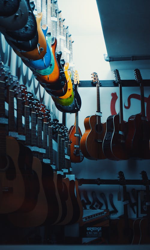 Brown Acoustic Guitars Hanged on White Wall