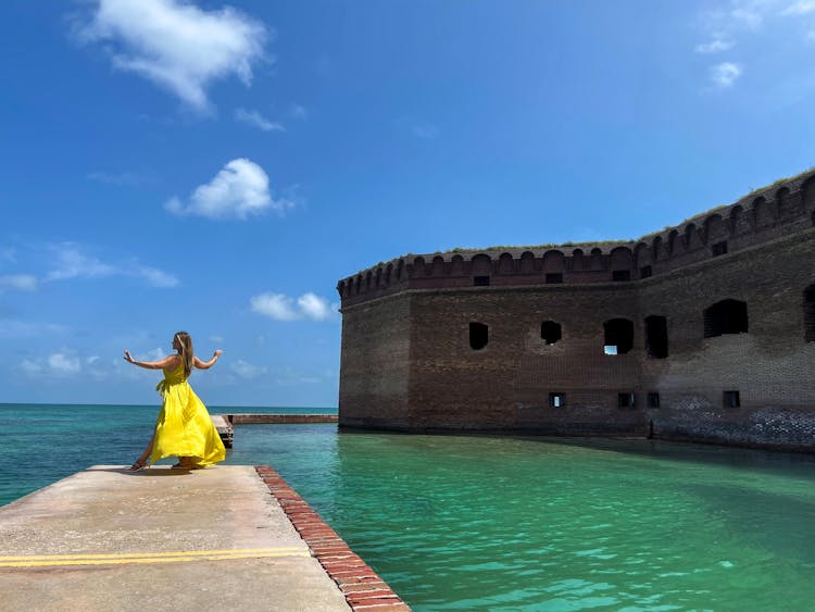 Woman Dancing On Pier By Fortress