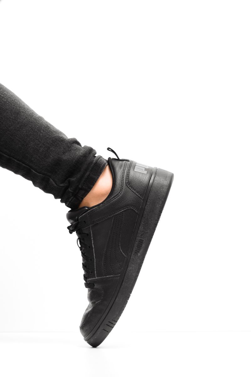 Zapatilla negra de perfil sobre fondo blanco