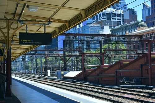 Free View of a railway station platform in Melbourne, Australia, showcasing urban architecture and transportation. Stock Photo