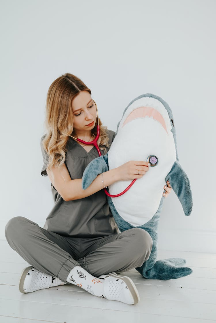 Woman In Scrubs Using Stethoscope On A Mascot 