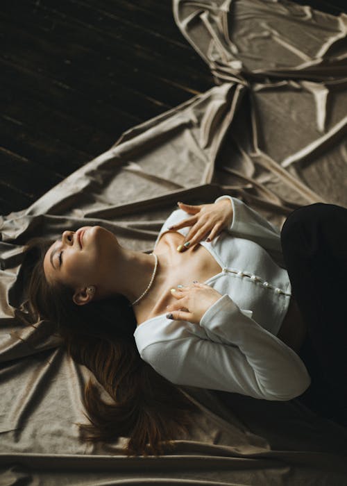 Woman Lying on Silk Fabric with Head Back