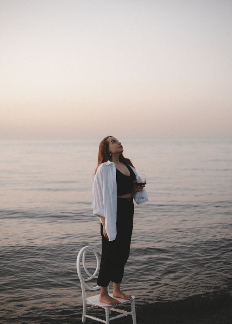 A Woman Looking Up While Standing On A Chair