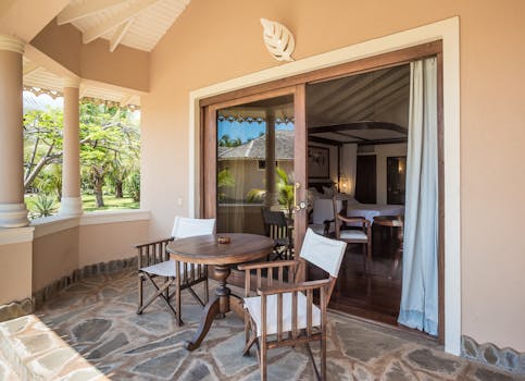Charming villa patio in Malindi, Kenya, featuring wooden chairs and a table.