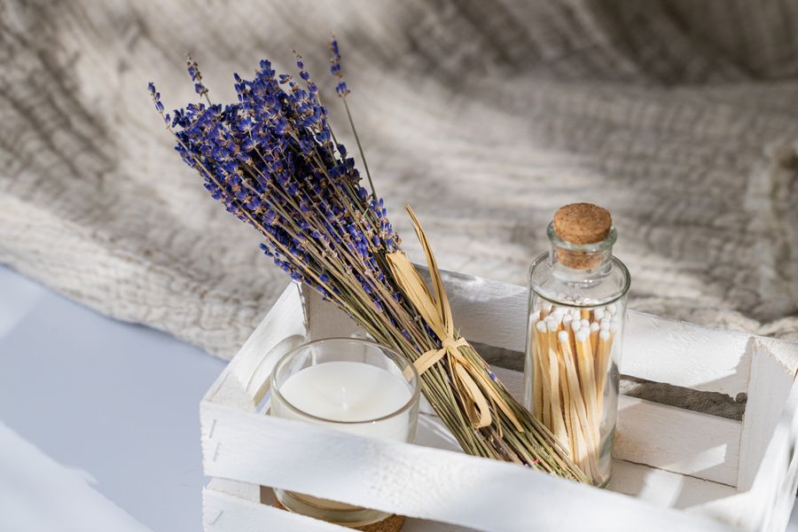 Dried lavender, a poured candle and matches in a crate — photo by Andrzej Gdula on Pexels