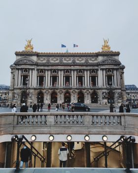 Iconic Palais Garnier facade with vibrant Paris street scene and classic architecture.