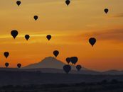 Hot Air Balloons Flying over the Mountains during Sunset