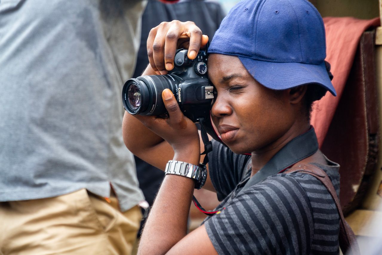 a focused young photographer taking pictures with a dslr camera outdoo