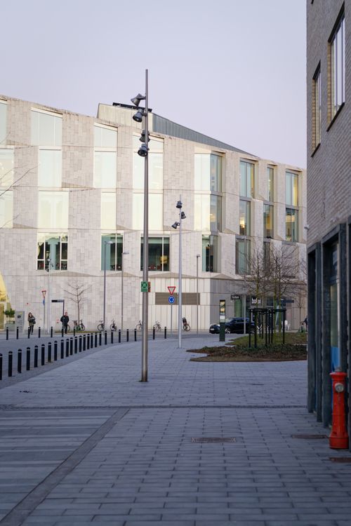 Free Street view of modern architecture and lamp posts under a cloudy sky. Stock Photo