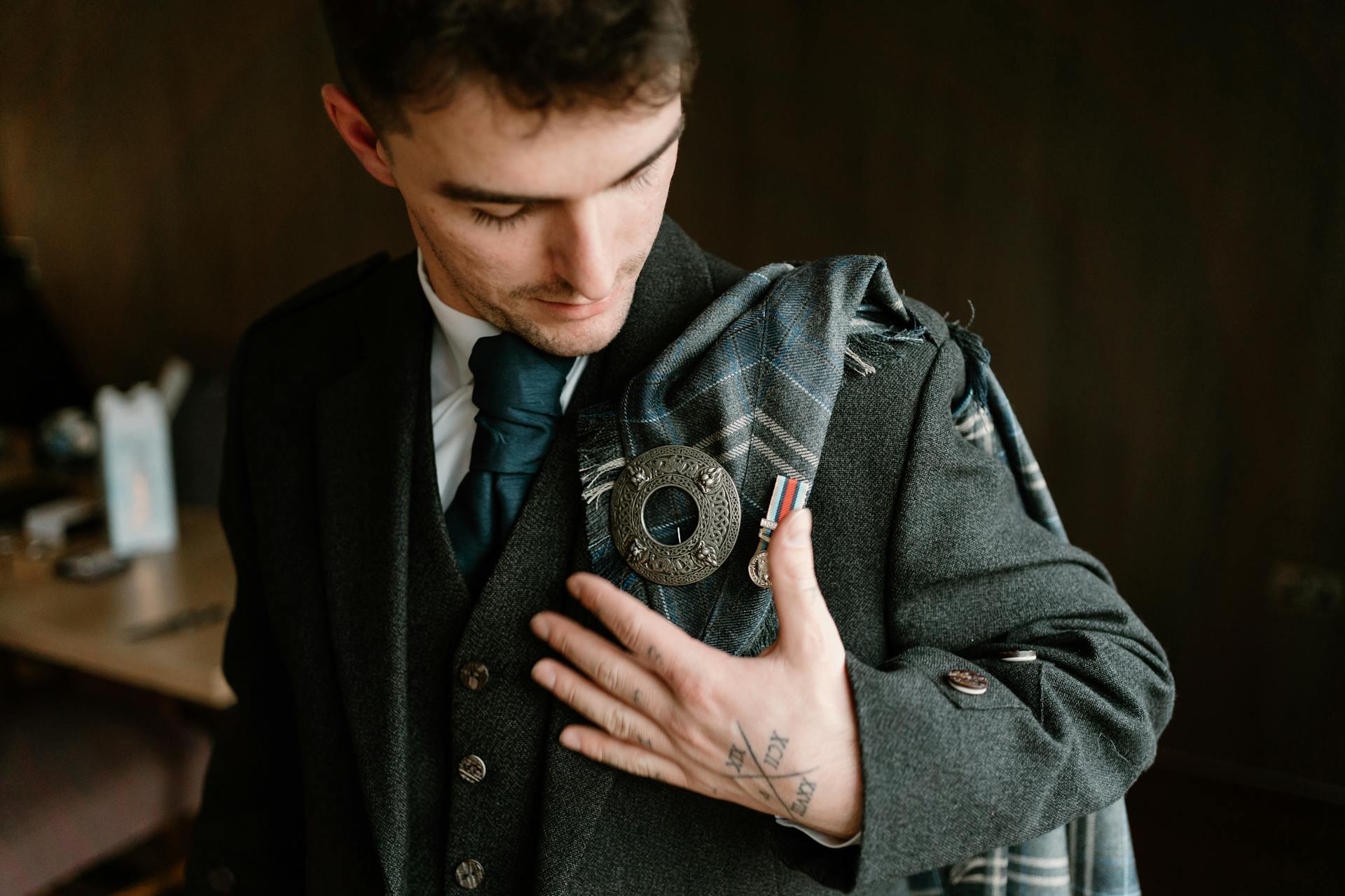 Groom Looking at His Pin on Tuxedo