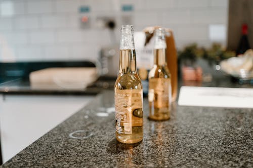 Two Glass Bottles on Marble Top Table