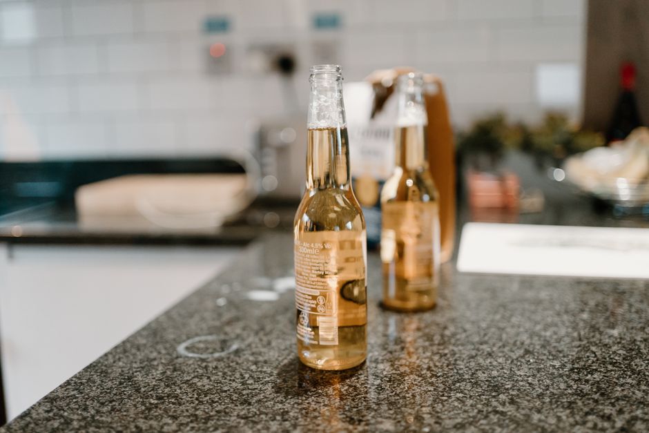 An inviting bottle of <span class="notranslate"><em>Sagres Beer</em></span> placed on a café table amidst social gathering.