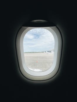 A serene view from an airplane window overlooking Banten airport with a cloudy sky.