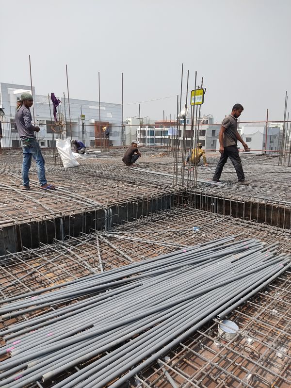 Workers constructing metal framework on building site — repairability
